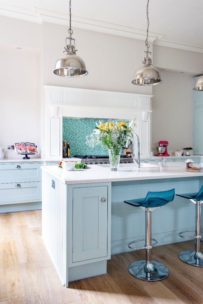 pale blue kitchen units with transparent blue bar stools at a blue and white kitchen island 