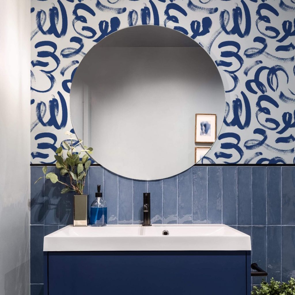 abstract navy bathroom wallpaper above rectangular blue tiles and a blue vanity unit