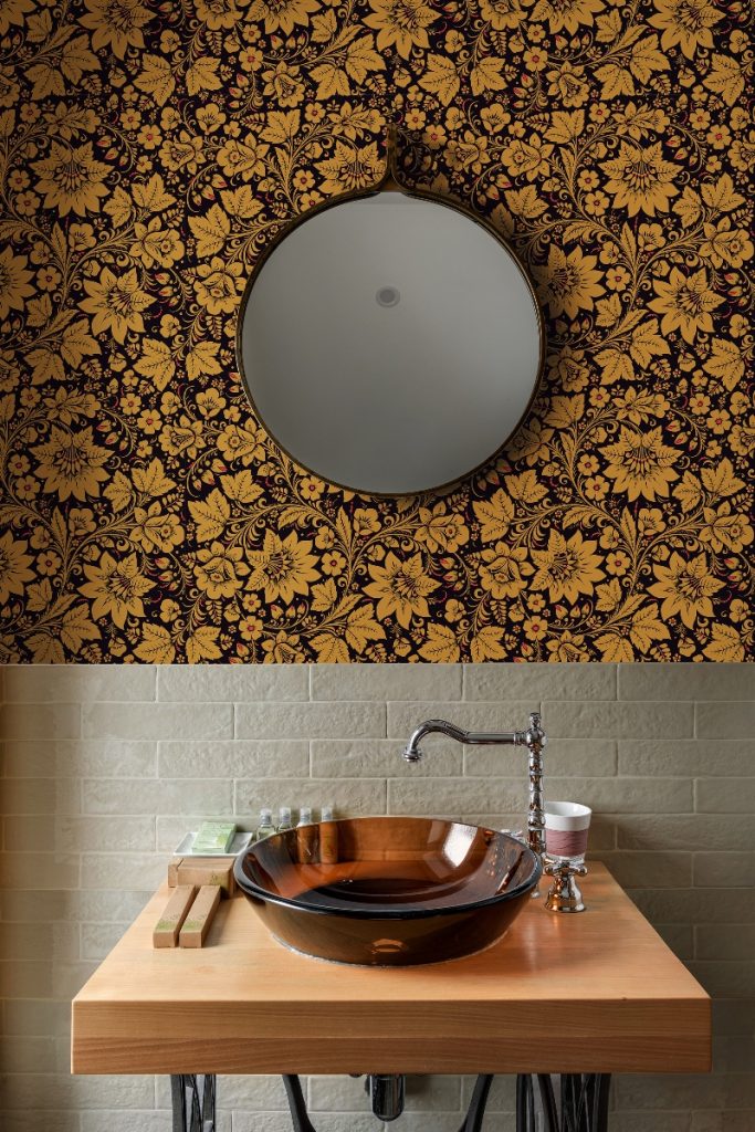 a gold floral design above a glass sink