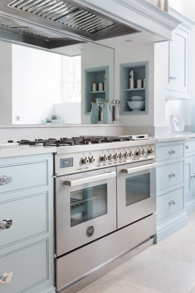 a double range cooker next to pastel cabinetry