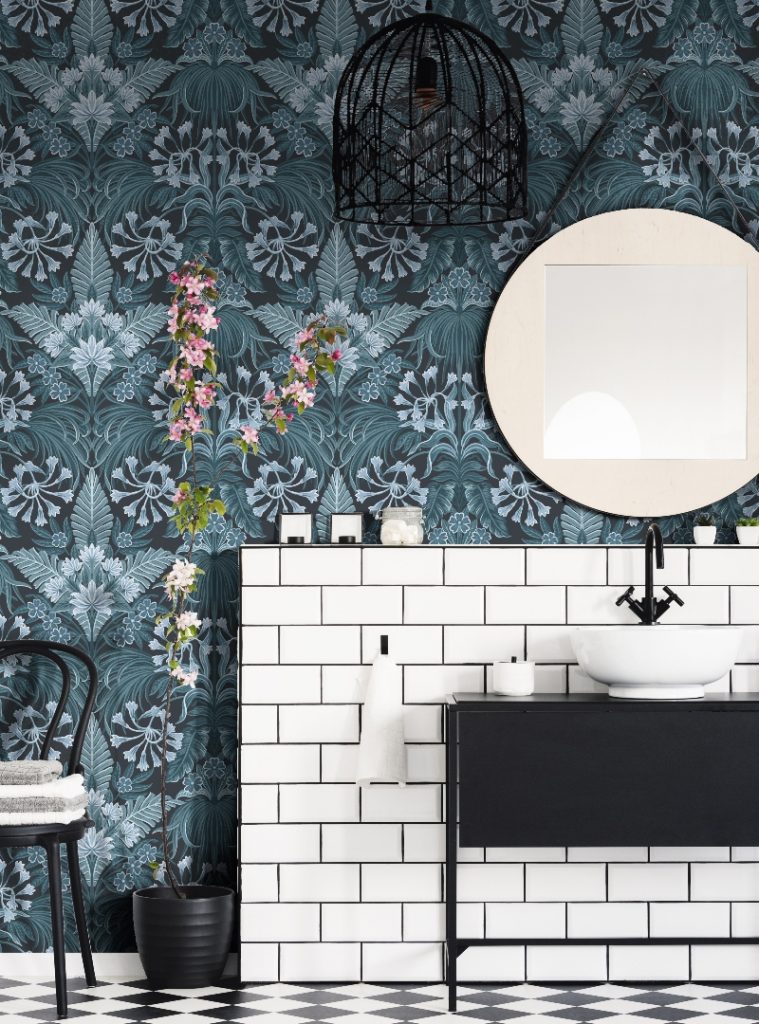 floral blue bathroom wallpaper above white metro brick tiles behind a black vanity unit