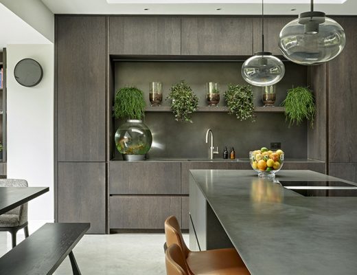 an open plan kitchen in dark wood designed by an interior designer
