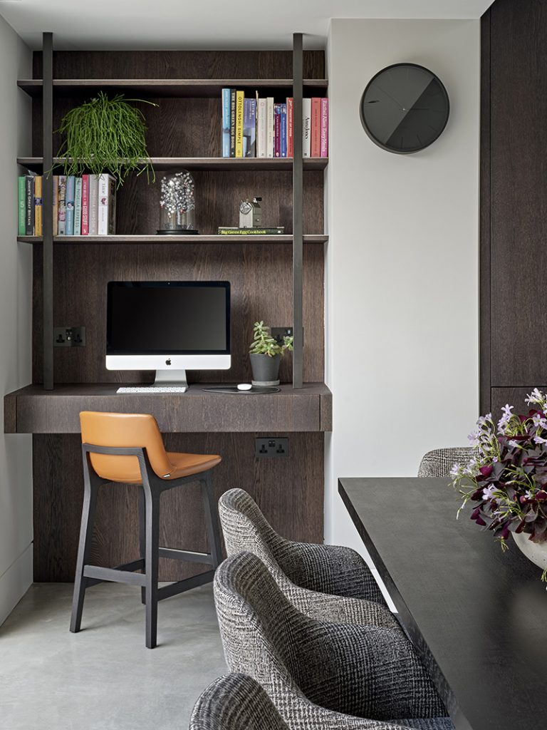 an open plan kitchen in dark wood designed by an interior designer