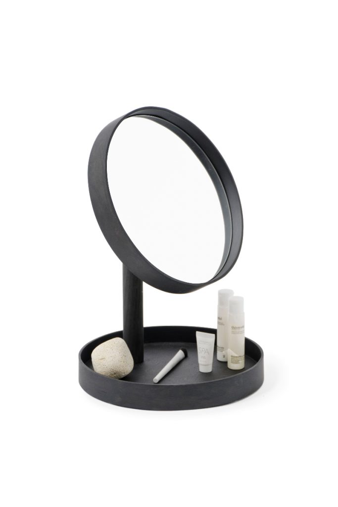 a freestanding black mirror with accessories in the bottom