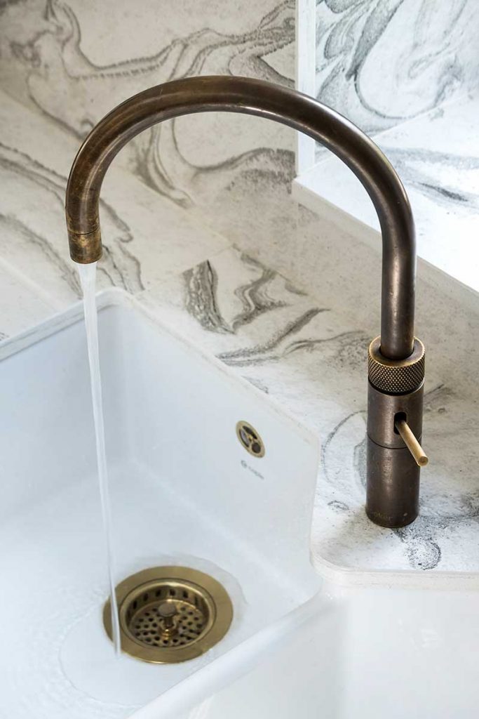 a marble-effect basin with copper tap