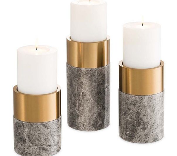a set of three candles in marble and gold holders
