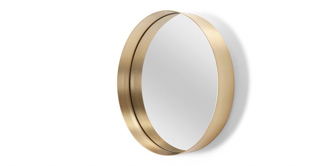 a brushed gold circular mirror