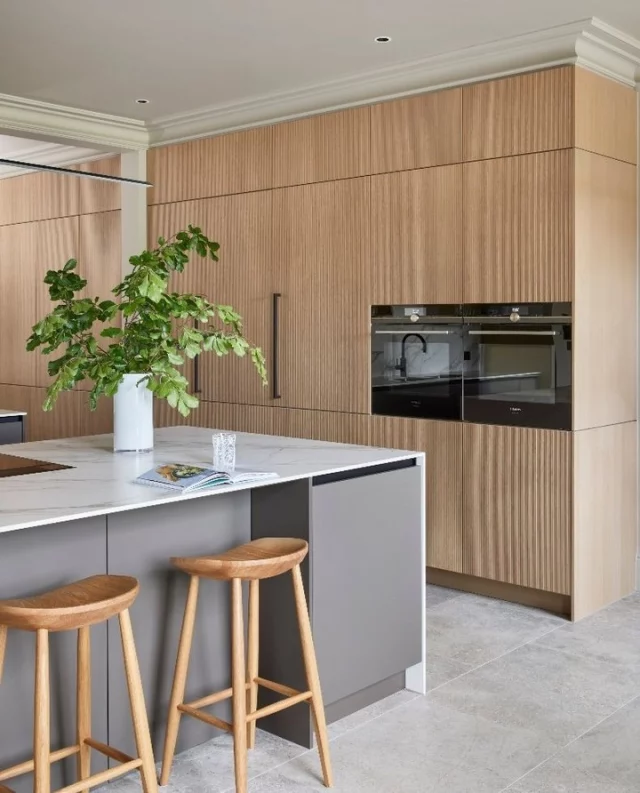 After building their first home 30 years ago, Deirdre and Anthony set out to create their dream space… again. What started as a modest farmhouse turned into a six-bedroom home with a pool house, all built around a 350-year-old cedar tree. 🌳⁠
⁠
What we love most? The kitchen. With its fluted oak details, gentle hues and organic textures, it’s a calming, characterful space that blends modern design with a real sense of warmth and personality! ✨⁠
⁠
Visit the link in bio to read more. 🔗⁠
⁠
📷: @darrenchung74⁠
Cabinetry: @snugkitchens⁠
Architect: @fowlerarchitectureandplanning⁠
Design: @studiohooton⁠
Developer: @shorewoodhomes